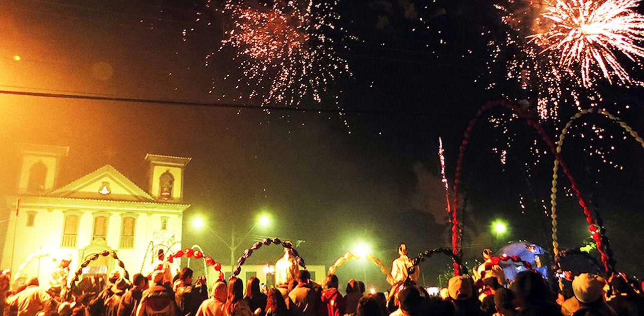 Fogos de artifício explodindo no céu sobre a praça durante a Cavalhada.